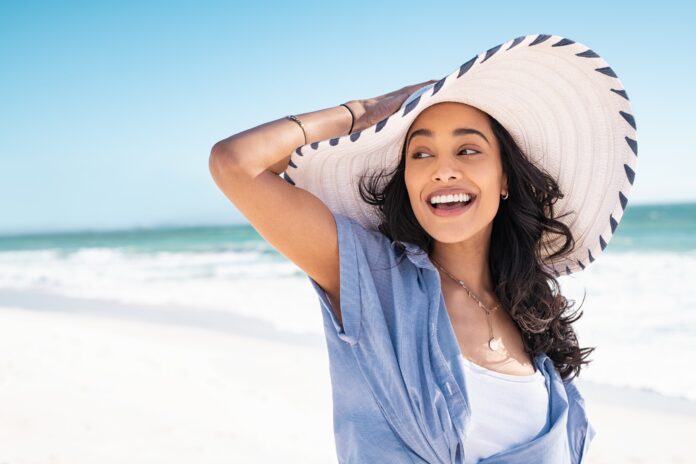 Carefree,Woman,With,White,And,Blue,Straw,Hat,Walking,At