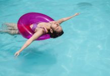 calm woman swimming in pool with swimming ring at resort